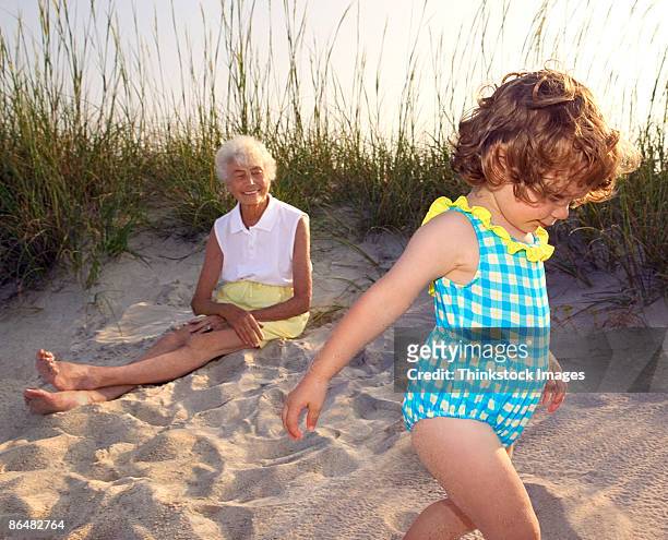 grandmother and granddaughter at beach - life si a beach stock pictures, royalty-free photos & images