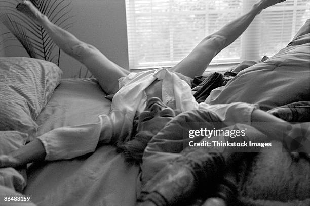 woman lying down with legs spread on bed - woman leg spread stock pictures, royalty-free photos & images