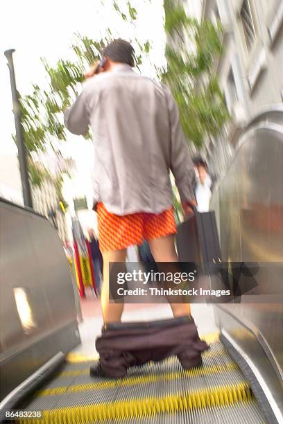 man on escalator with pants down - pants down bildbanksfoton och bilder