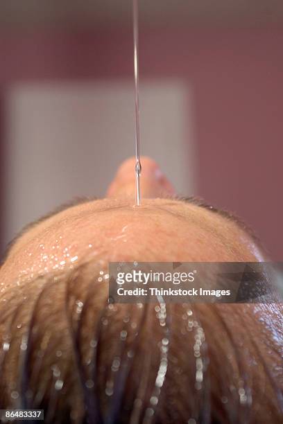 close-up of woman's head during hot oil therapy - shirodhara stock pictures, royalty-free photos & images