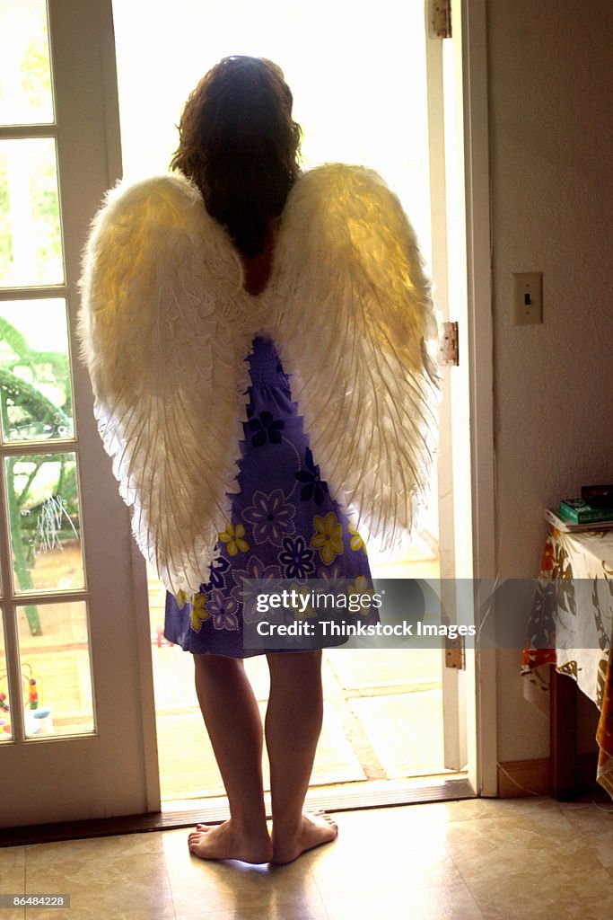 Woman wearing angel wings in doorway