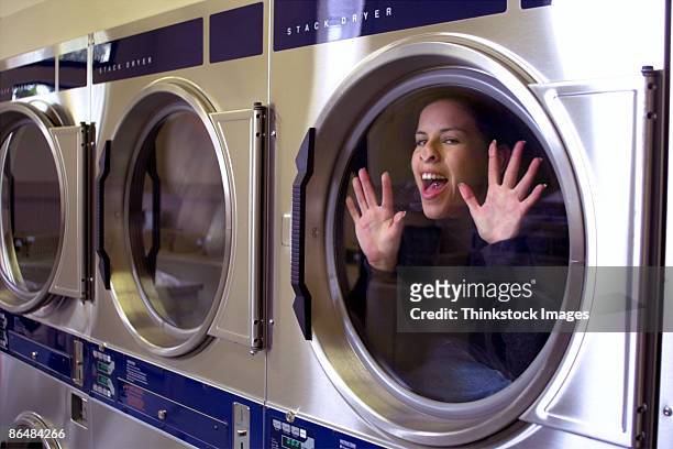 woman trapped inside laundry facility dryer - stuck indoors stock pictures, royalty-free photos & images
