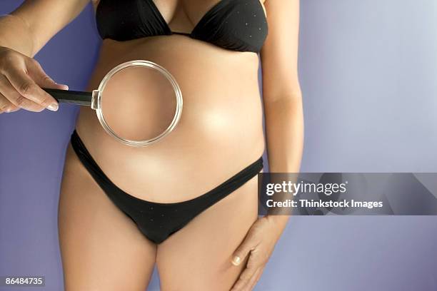 pregnant woman with magnifying glass - micro swimsuit foto e immagini stock