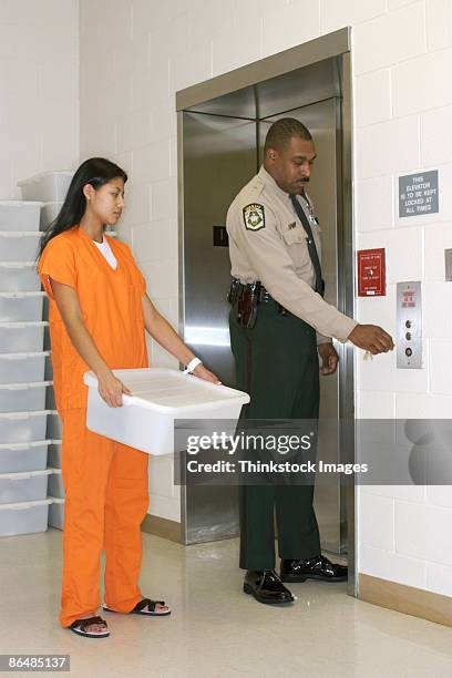 police officer with inmate at elevator - female-inmates stock pictures, royalty-free photos & images
