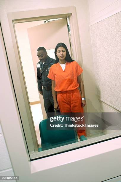 corrections officer and inmate standing in visiting room - prison guard stockfoto's en -beelden