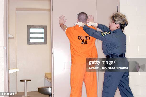 corrections officer searching inmate - warders stock pictures, royalty-free photos & images