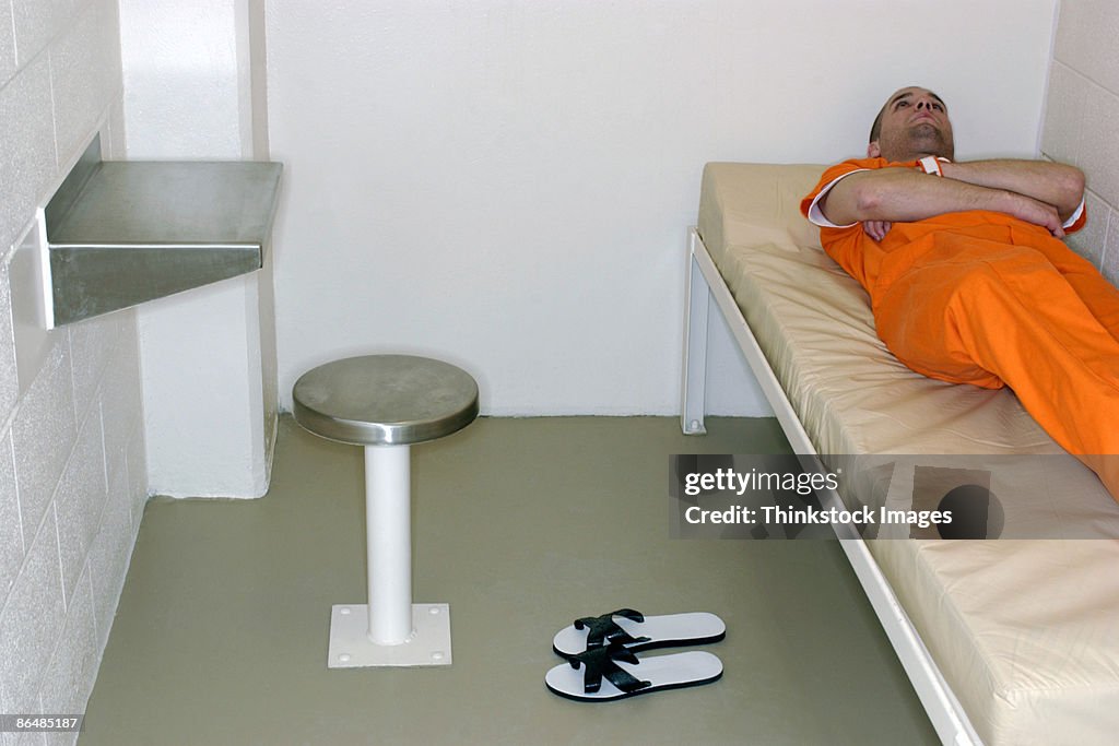 Inmate lying on bed in prison