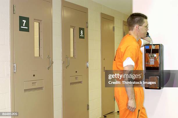 inmate using pay phone - prison uniform stock pictures, royalty-free photos & images