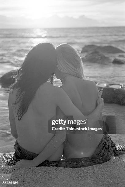 topless couple sitting on beach at sunset - buttocks gay stock-fotos und bilder