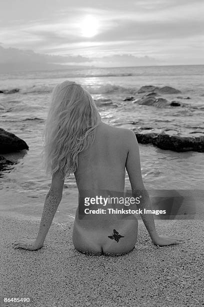 nude woman sitting on beach - butterfly tattoos stock pictures, royalty-free photos & images