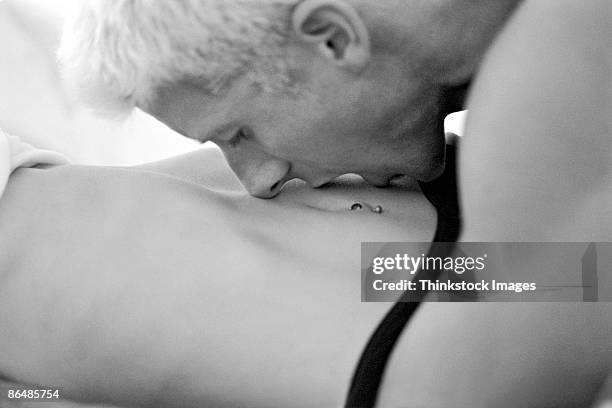 man kissing woman's stomach - intimpiercing stock-fotos und bilder