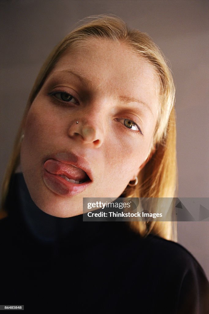 Woman pressing tongue against glass