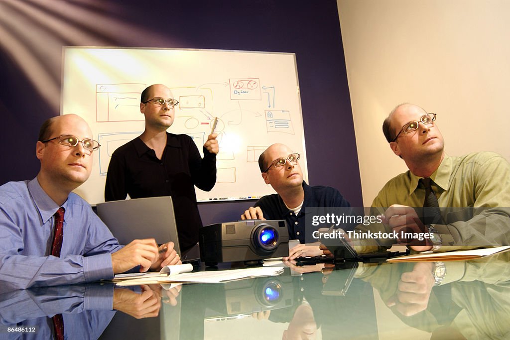 Businesspeople with same head watching presentation