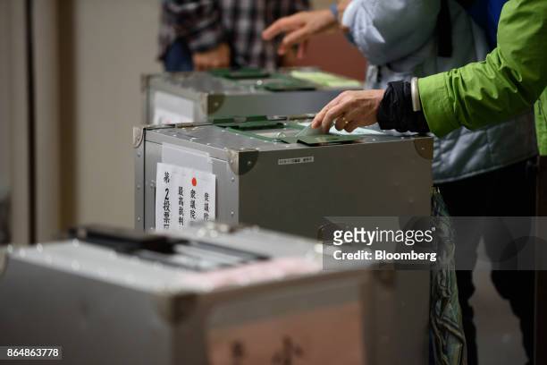 Voter casts a ballot at a polling station during a general election in Tokyo, Japan, on Sunday, Oct. 22, 2017. More than 100 million voters began...