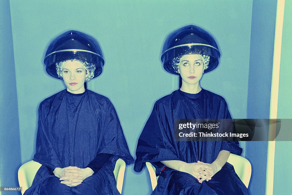 Women sitting in salon hair dryers