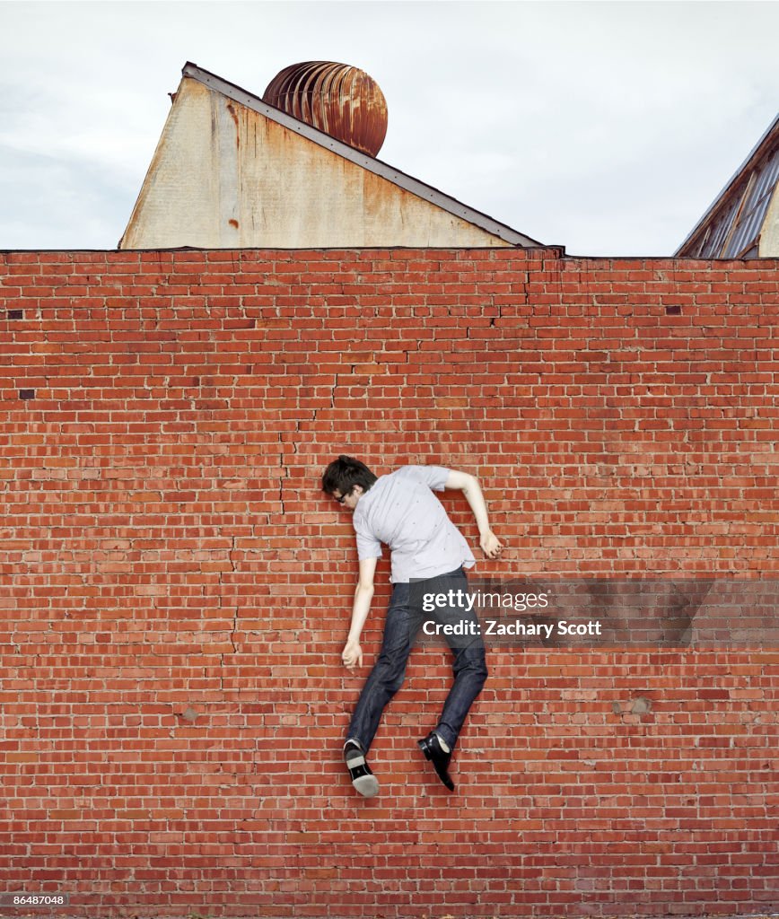 Pco Wal Man Stuck Weightlessly On Red Brick Wall High-Res Stock Photo - Getty ...