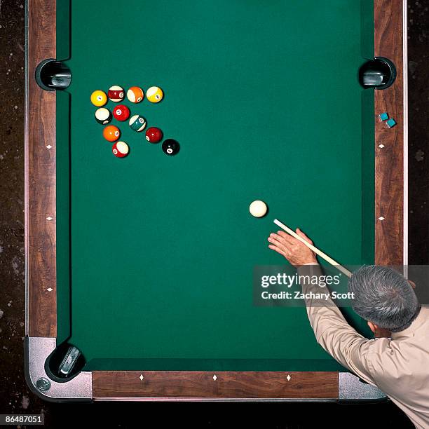 man aims at pool balls in arrow arrangement - billar deporte de taco fotografías e imágenes de stock