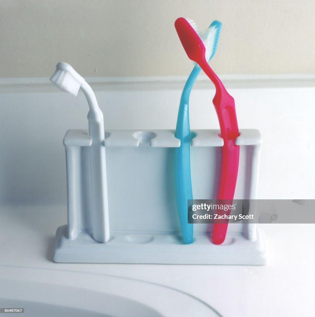 Toothbrushes kiss while another gets left out