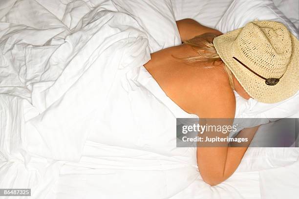 woman wearing cowboy hat in bed - cowboy sleeping stock-fotos und bilder