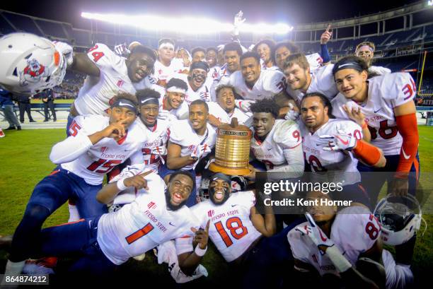 Members of the Fresno State Bulldogs football celebrate with the school rivalry Oil Can Trophy after winning the game against the San Diego State...