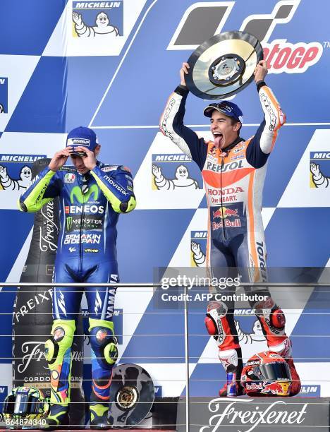 Honda rider Marc Marquez of Spain celebrates his victory on the podium with second-place Yamaha rider Valentino Rossi of Italy at the end of the...