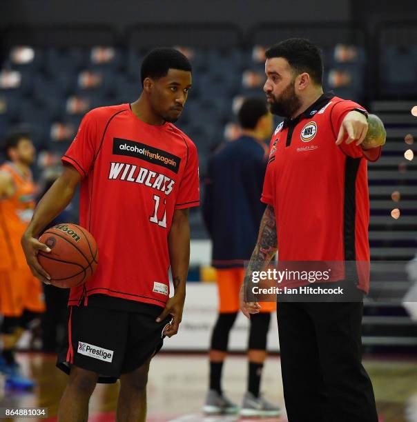 Bryce Cotton of the Wildcats takes instructions from a support staff memmber before the start of the round three NBL match between the Cairns Taipans...