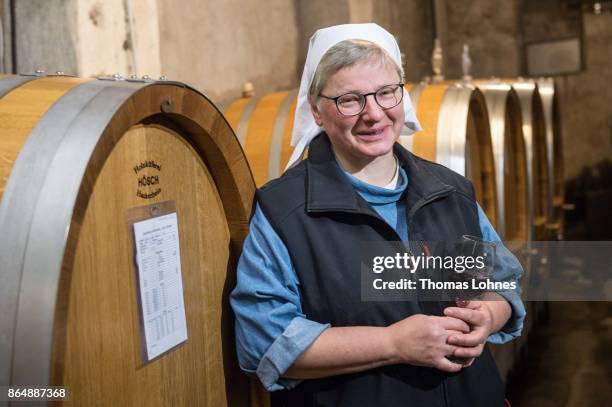 Nun Thekla of St. Hildegard Abbey pictured with a Spaetburgunder red wine in the cellar on October 20, 2017 near Rudesheim on the Rhine, Germany. The...