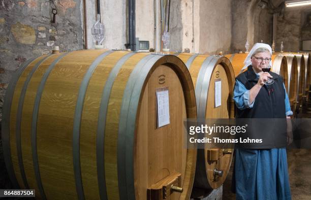 Nun Thekla of St. Hildegard Abbey smells a Spaetburgunder red wine in the cellar on October 20, 2017 near Rudesheim on the Rhine, Germany. The St....