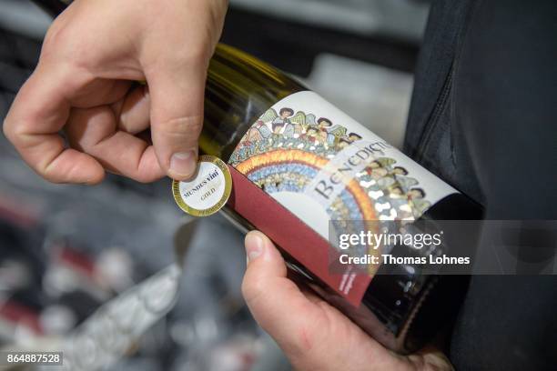 Nun Thekla of St. Hildegard Abbey labes wine bottels with an award label in the cellar on October 20, 2017 near Rudesheim on the Rhine, Germany. The...