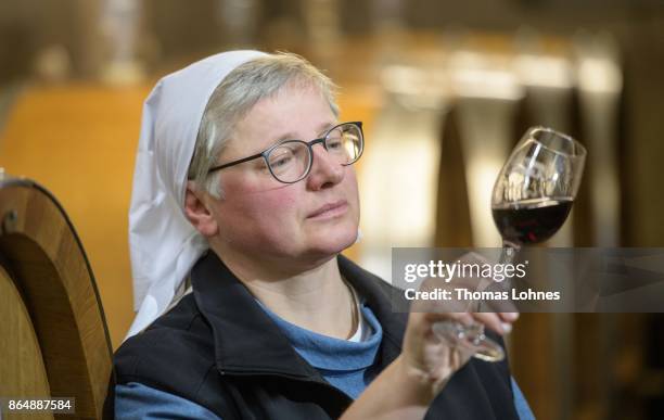 Nun Thekla of St. Hildegard Abbey looks to a Spaetburgunder red wine in the cellar on October 20, 2017 near Rudesheim on the Rhine, Germany. The St....