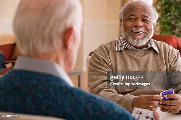 men playing cards - senior men playing cards stock pictures, royalty-free photos & images