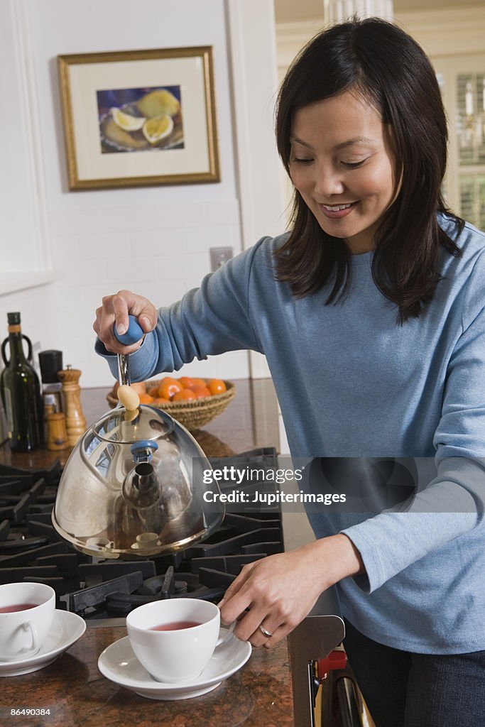 Woman pouring tea in the kitchen