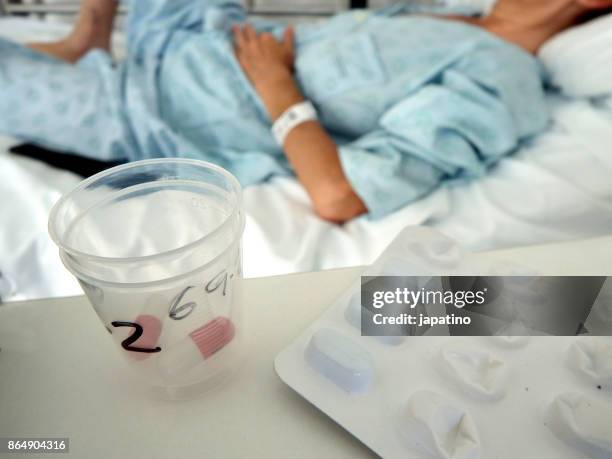 sick woman receiving medication - ストレプトミセス ストックフォトと画像