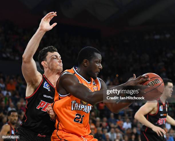 Nnanna Egwu of the Taipans takes the ball ahead of Angus Brandt of the Wildcats during the round three NBL match between the Cairns Taipans and the...