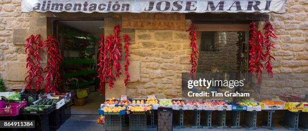 Red chillies, fresh vegetables and fruit displayed outside Alimentacion Jose Mari food shop in Laguardia, Rioja-Alavesa, Spain.