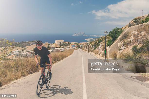 cycling up the cumbre del sol - calpe stockfoto's en -beelden