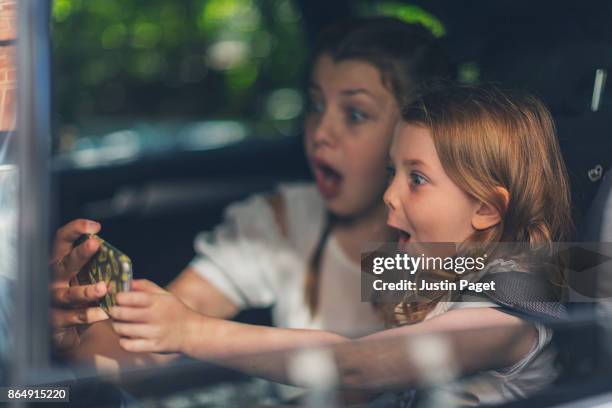 sisters doing silly face selfie in car - children in car stock pictures, royalty-free photos & images