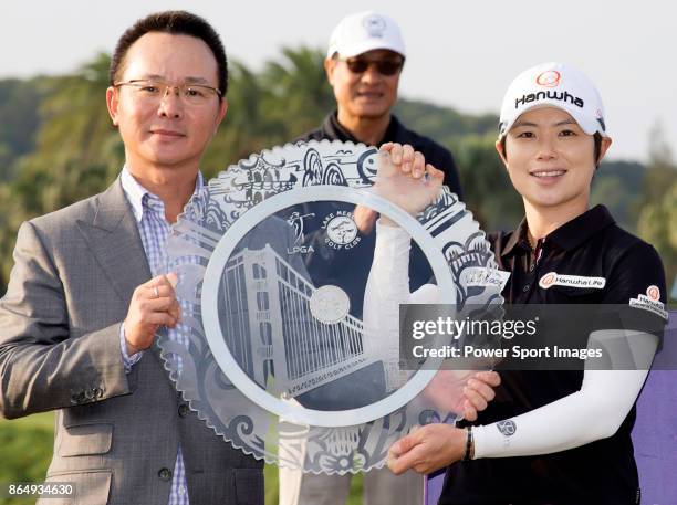 Eun-Hee Ji of South Korea poses for a photo while holding the trophy with Swinging Skirts Golf Foundation Chairman Johnson Wang on the 18th green...
