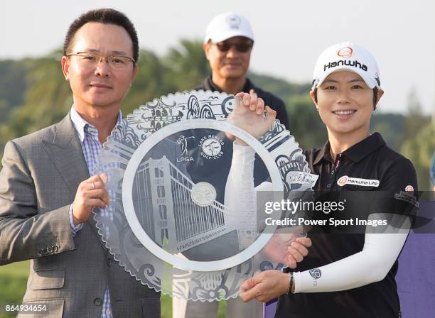 Eun-Hee Ji of South Korea poses for a photo while holding the trophy with Swinging Skirts Golf Foundation Chairman Johnson Wang on the 18th green...