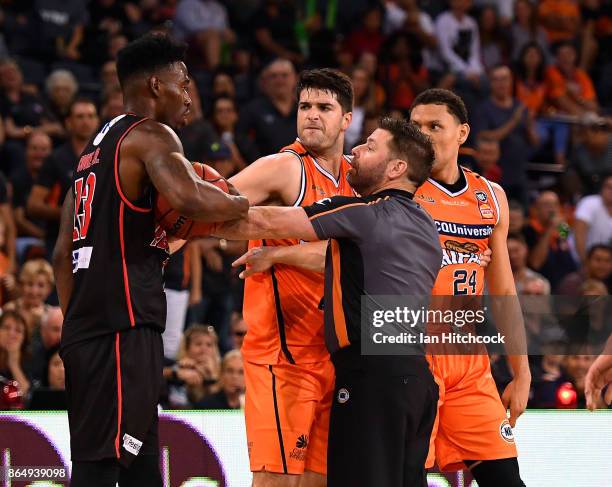Derek Cooke Jr of the Wildcats is involved in a scuffle with Michael Carrera and Stephen Weigh of the Taipans during the round three NBL match...