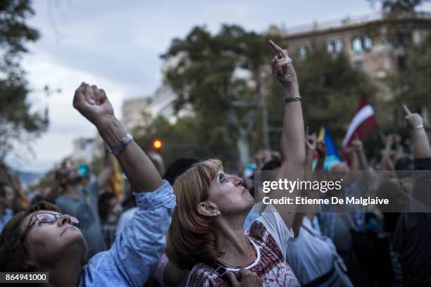 Protesters gesture at a hovering police helicopter during a rally to demand the release of imprisoned Catalan leaders Jordi Sanchez and Jordi Cuixart...