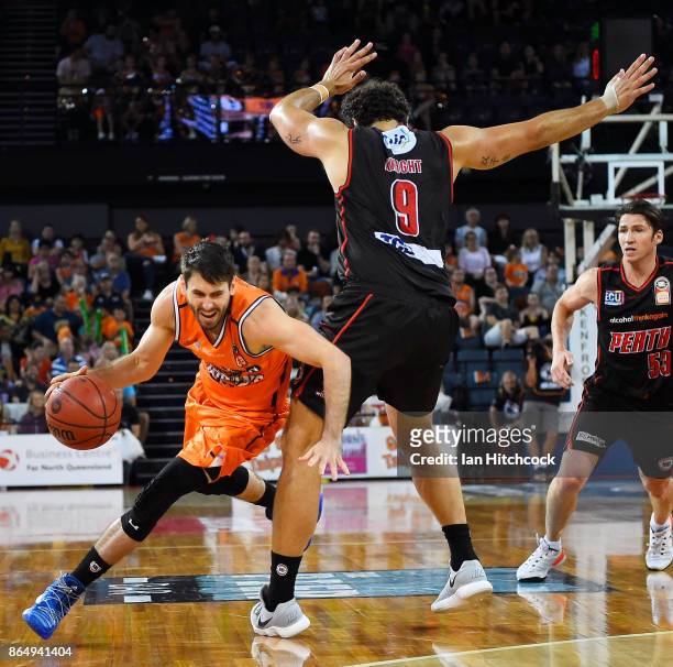 Jarrad Weeks of the Taipans drives to the basket past Matthew Knight of the Wildcats during the round three NBL match between the Cairns Taipans and...