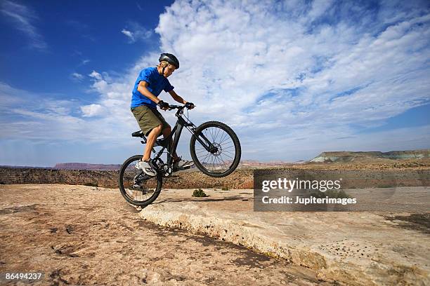 teenage boy doing trick on bicycle - wheelie stock pictures, royalty-free photos & images