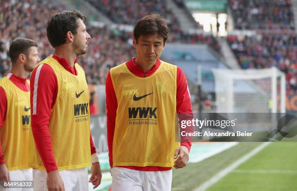 Marcel Heller, Gojko Kacar and Ja-Cheol Koo of FC Augsburg warm up at the sideline during the Bundesliga match between FC Augsburg and Hannover 96 at...