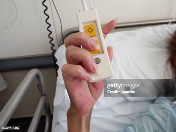 sick woman turns off the light in his room in the hospital - ストレプトミセス ストックフォトと画像