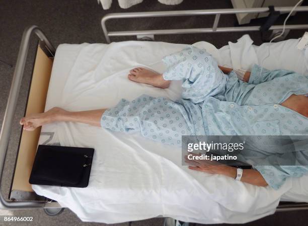 elevated view of a sick woman lying on the bed - helicobacter pylori stock-fotos und bilder