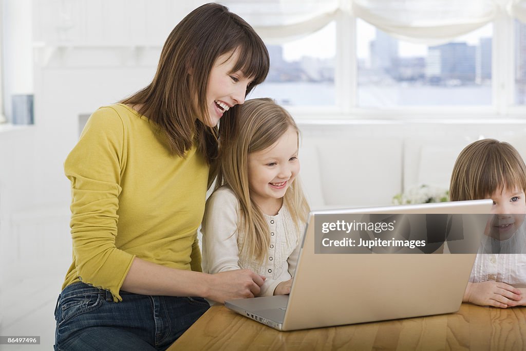 Mother and daughters on laptop computer