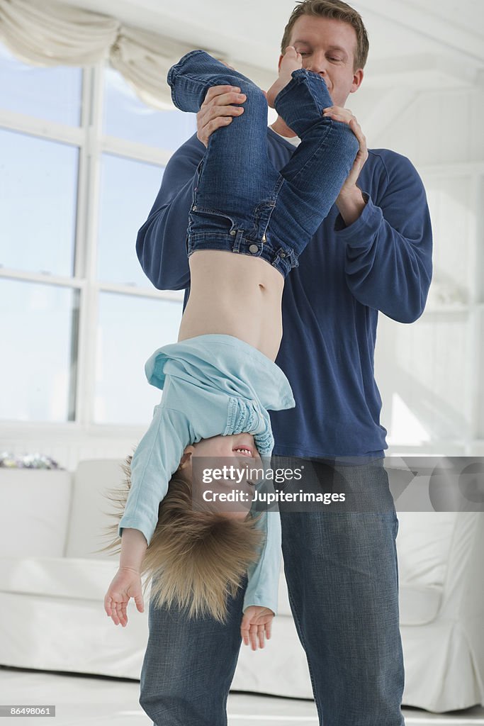 Father hanging daughter upside down