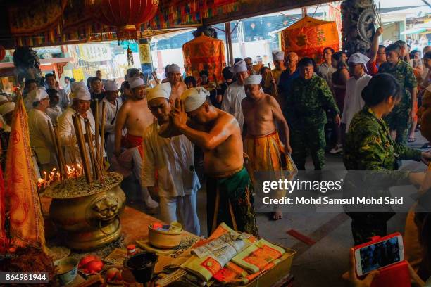 Chinese devotees perform a feeding of the Soldiers prayer ceremony during The Nine Emperor Gods Festival inside the temple on October 22, 2017 in...