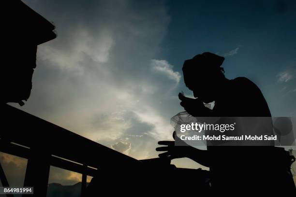 Chinese devotees perform a feeding of the Soldiers prayer ceremony during The Nine Emperor Gods Festival inside the temple on October 22, 2017 in...